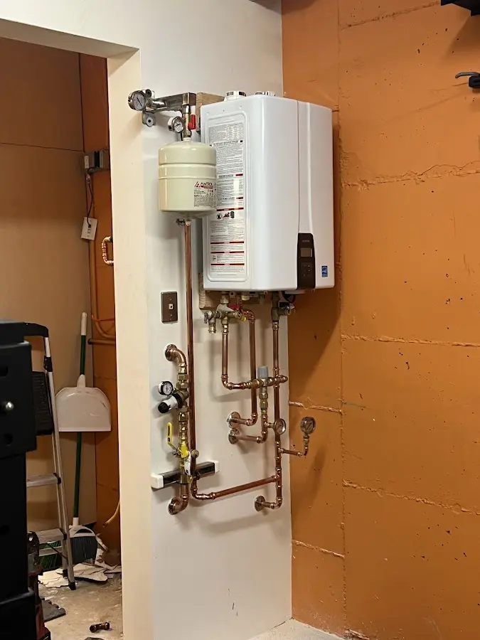 Plumbing technician inspecting water heater connections in Louisville